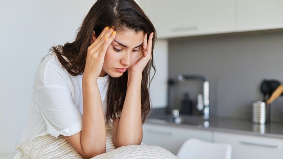 alcohol and anxiety experienced bya woman sitting at her bed.